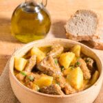 spezzatino di carne di vitello con patate servito in una ciotola di terracotta